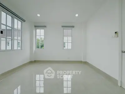 Spacious empty room with large windows and polished tile flooring, perfect for customization.