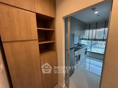 Modern kitchen with washing machine and sleek cabinetry in bright apartment