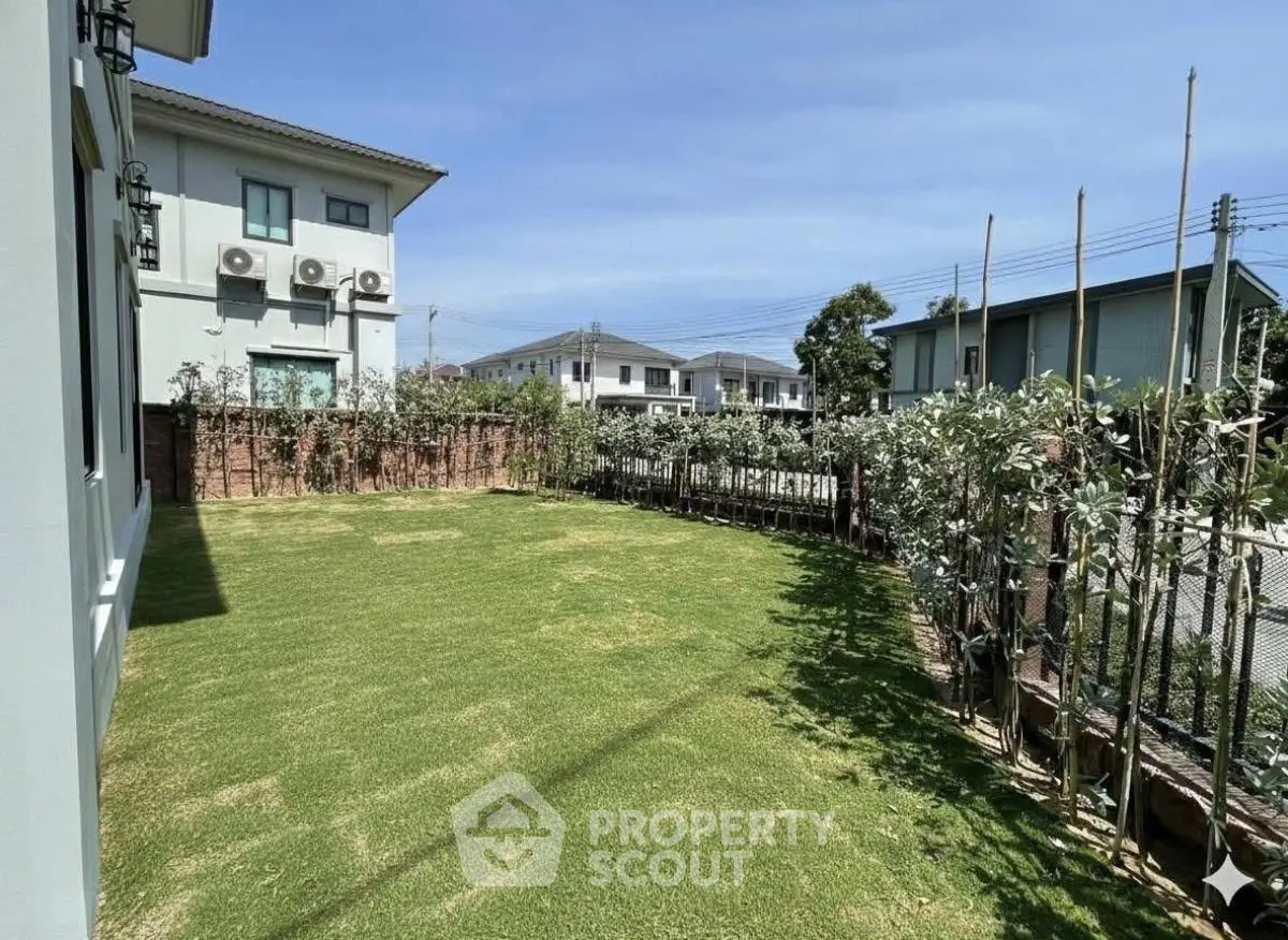 Spacious green garden in modern residential area with clear blue sky