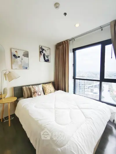 Bright bedroom with large window offering stunning city view, modern decor, and cozy ambiance.