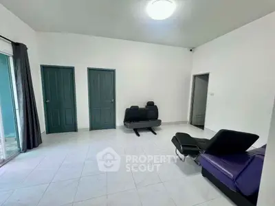 Spacious room with modern recliners and tiled flooring, featuring dual doors and ample natural light.