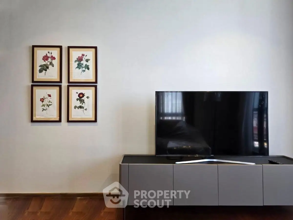 Modern living room with sleek TV setup and elegant floral wall art.