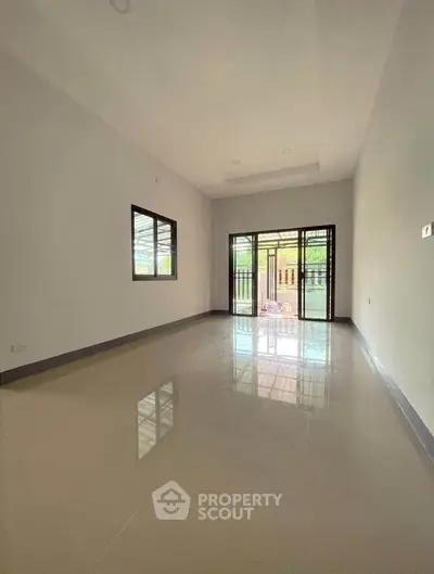 Spacious empty room with large windows and glossy tiled floor