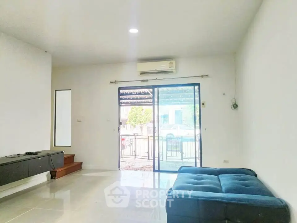 Spacious living room with modern decor and large sliding glass doors leading to a patio.