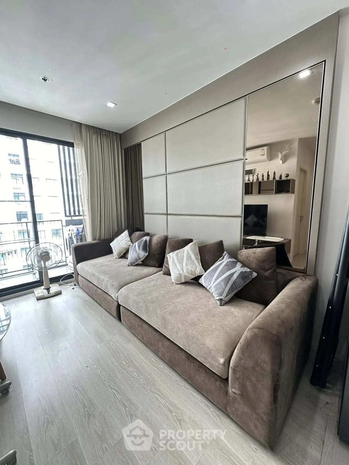 Modern living room with large sofa and balcony view in stylish apartment