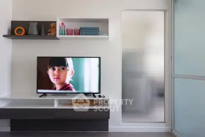 Modern living room with sleek TV setup and stylish shelving in a contemporary apartment.