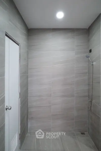 Modern minimalist bathroom with sleek gray tiles and a walk-in shower.