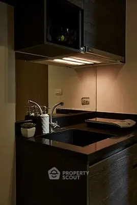 Modern kitchen with sleek black countertops and contemporary fixtures.
