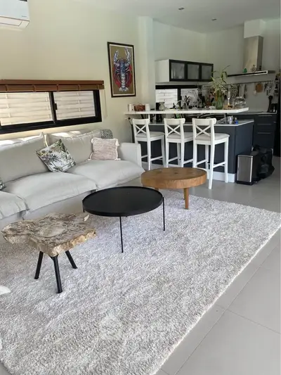 Stylish open-plan living room with modern kitchen and cozy seating area, perfect for entertaining.