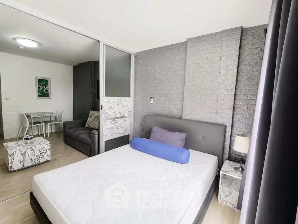 Modern bedroom with stylish decor and sliding glass doors leading to a cozy living area.