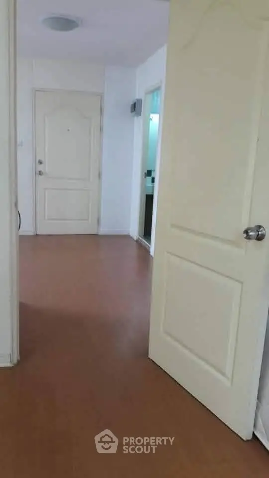 Spacious apartment entrance with wooden flooring and open doors