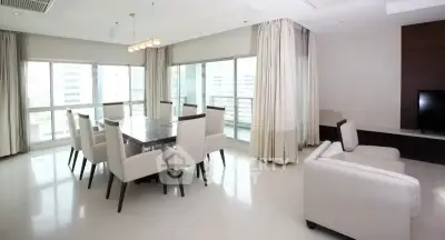 Spacious modern living room with large windows and elegant dining area in a luxury apartment.