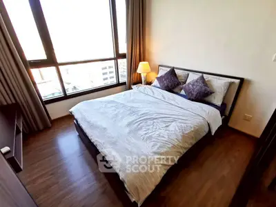 Cozy bedroom with large window and stylish decor in modern apartment