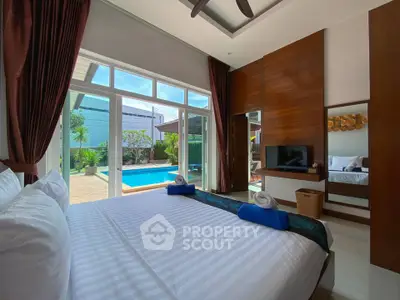 Luxurious bedroom with pool view, modern decor, and ample natural light for a serene living experience.