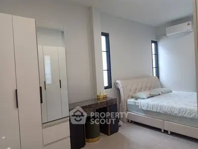 Modern bedroom with stylish furniture and natural light, featuring a comfortable bed and sleek wardrobe.