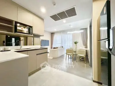 Modern open-layout kitchen and living room with sleek design and natural light.