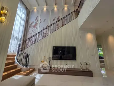 Luxurious living room with high ceilings and elegant staircase