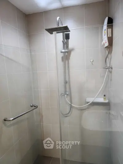 Modern bathroom with sleek shower and water heater in a tiled enclosure.