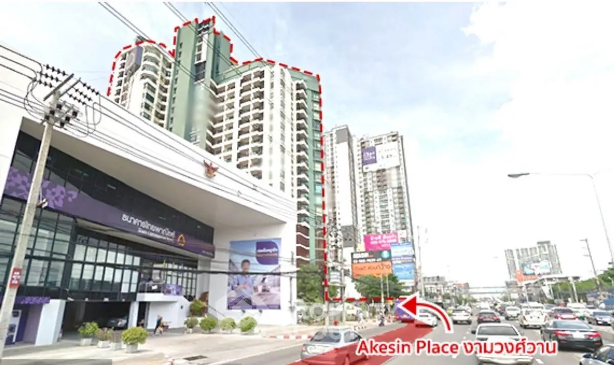 High-rise residential building Akesin Place with street view in bustling urban area.