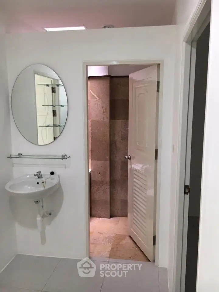 Modern bathroom with round mirror and sleek design