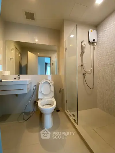 Modern bathroom with glass shower and sleek fixtures in a contemporary apartment.