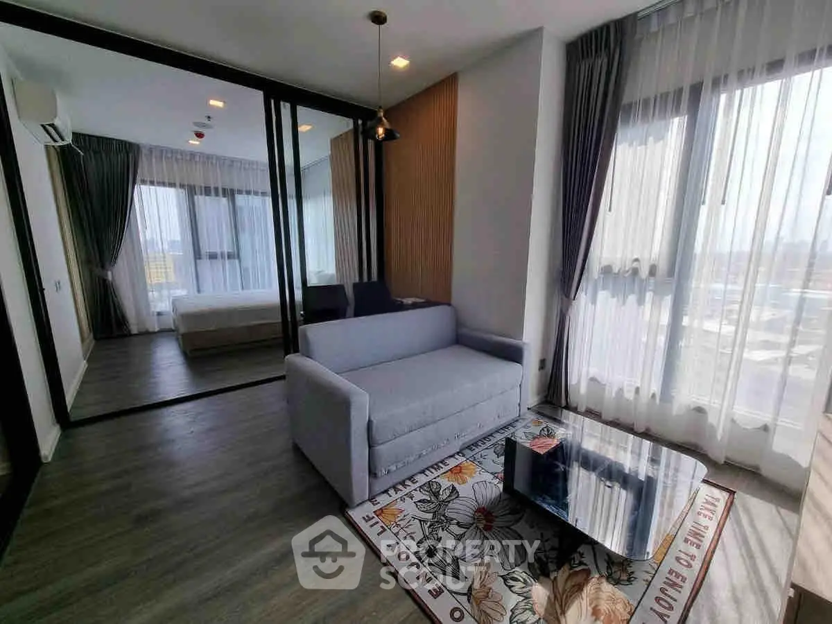 Modern living room with large windows and stylish decor in a contemporary apartment.