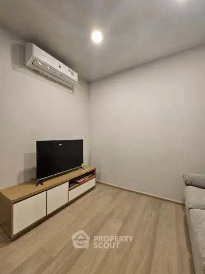 Cozy living room with modern air conditioning and sleek TV setup.