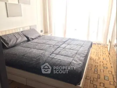 Spacious bedroom with large windows and modern decor, perfect for relaxation.