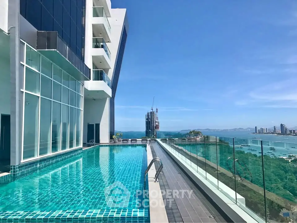 Luxurious rooftop pool with stunning ocean view in modern high-rise building.