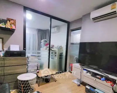 Modern living room with air conditioning and sliding glass doors in a cozy apartment.