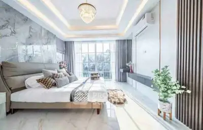 Luxurious bedroom with elegant decor and large windows offering natural light.