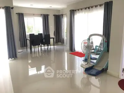 Spacious living room with sleek dining set and children's play area