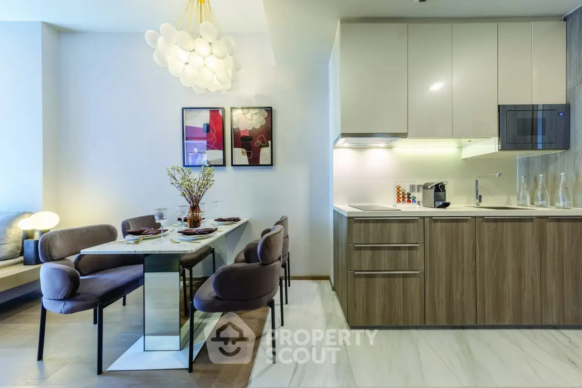 Modern open-layout kitchen and dining area with stylish decor and elegant lighting.