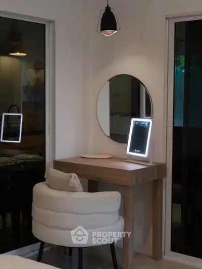 Elegant bedroom vanity setup with modern mirror and cozy chair