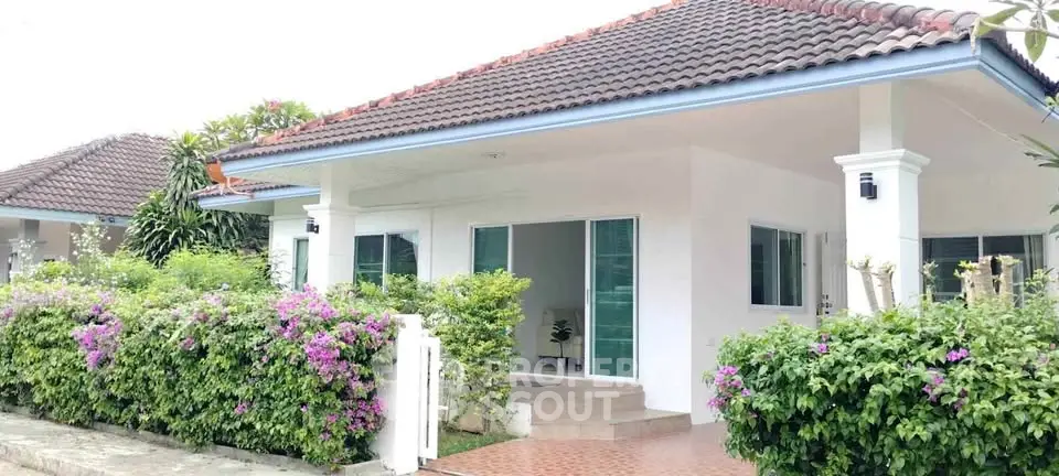 Charming single-story home with lush garden and tiled roof, perfect for serene living.