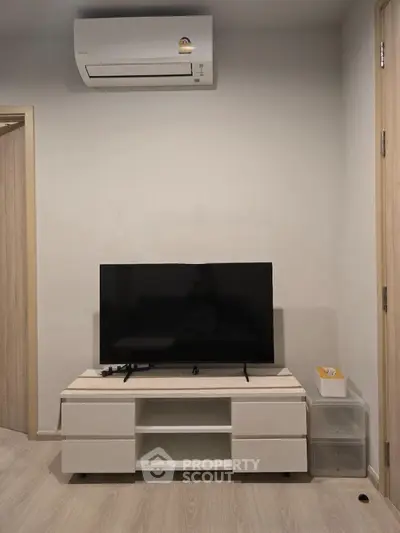Modern living room with sleek TV stand and air conditioning unit, perfect for cozy entertainment.
