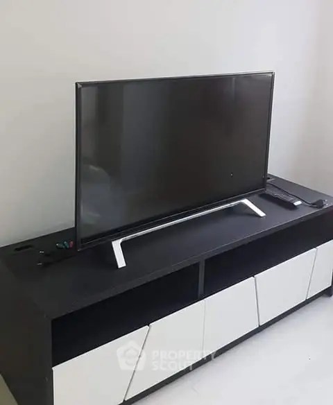 Modern living room with sleek TV stand and flat-screen television.