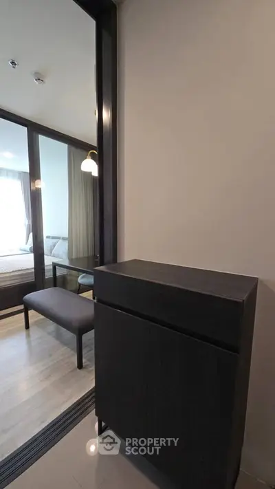 Modern bedroom entrance with sleek storage cabinet and glass partition