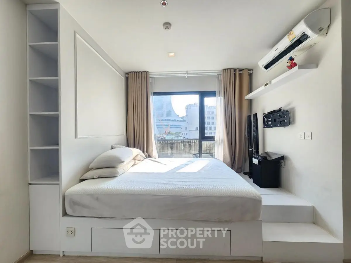 Modern bedroom with city view, featuring built-in storage and air conditioning.