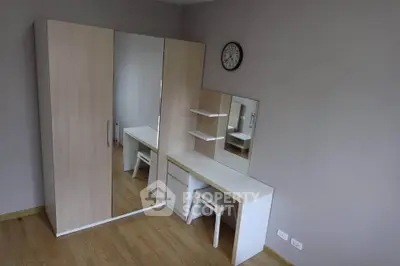 Spacious bedroom with modern wardrobe and vanity set, perfect for stylish living.