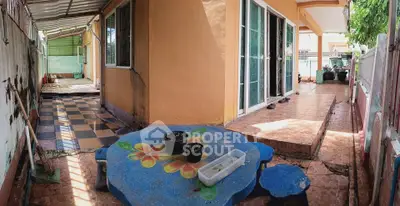 Charming outdoor patio with colorful table and tiled walkway in cozy residential property.
