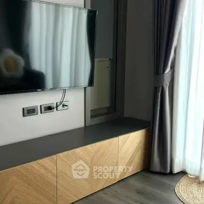 Modern living room with wall-mounted TV and stylish wooden cabinet