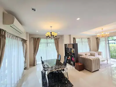 Spacious living room with elegant dining area and large windows for natural light