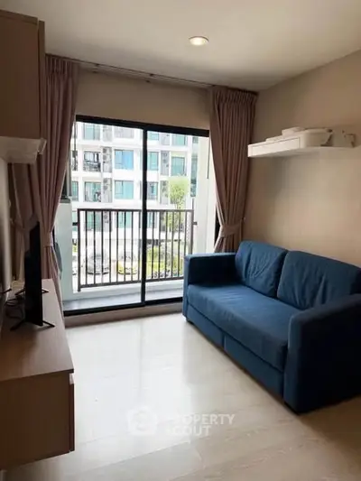 Cozy living room with blue sofa and balcony view in modern apartment