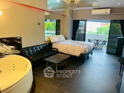 Luxurious studio apartment with jacuzzi and balcony, featuring modern decor and ample natural light.