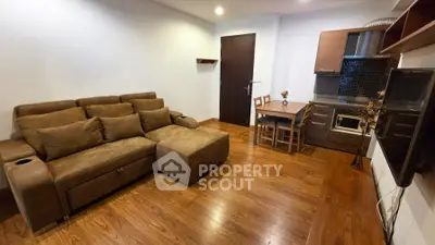 Cozy living room with brown sofa and compact kitchen area, perfect for modern living.