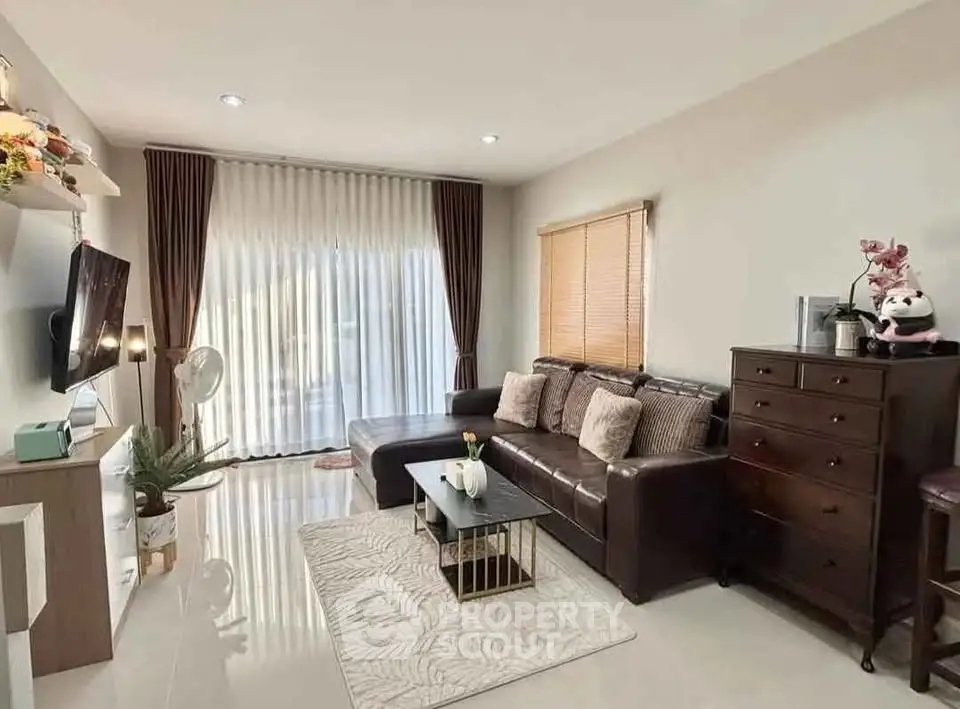 Stylish living room with modern decor and large window for natural light.