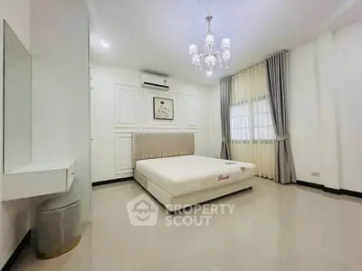 Spacious modern bedroom with elegant chandelier and large windows
