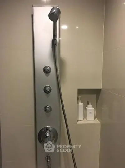 Modern bathroom shower panel with sleek design and built-in shelf for toiletries.