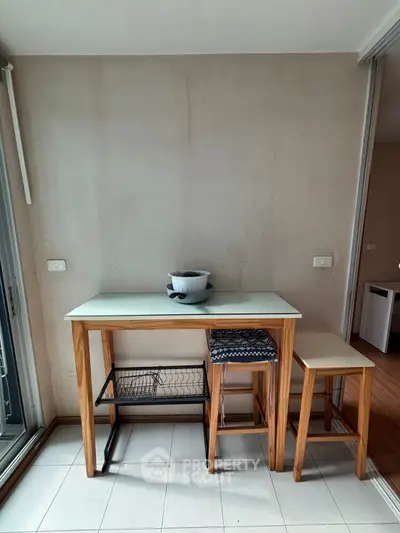 Cozy dining nook with wooden table and stools, perfect for small spaces.